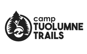 Camp Tuolumne Trails logo featuring two conifers in black, and a silhouette of a person in a wheelchair with arms raised. Across the wheel of the chair are two hands reaching toward each other.